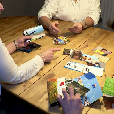 Famille qui trie des photos sur une table en bois, famille d'accueil Vaud
